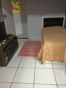 a bedroom with a bed and a red rug at Lugar pra relaxar...Perto de tudo .. in Búzios