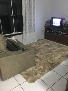 a living room with a couch and a television at Lugar pra relaxar...Perto de tudo .. in Búzios
