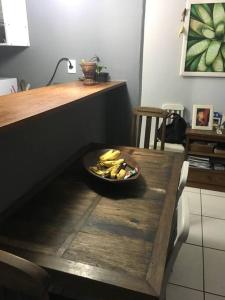 un plato de plátanos en una mesa de madera en una cocina en Lugar pra relaxar...Perto de tudo .., en Búzios