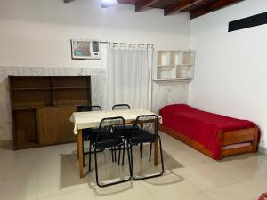 a room with a table and chairs and a bed at Amplio monoambiente in Bella Vista