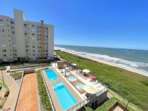 - une vue sur la plage depuis le balcon de l'hôtel dans l'établissement Condomínio Resort Pé na Areia - Barra velha, à Barra Velha