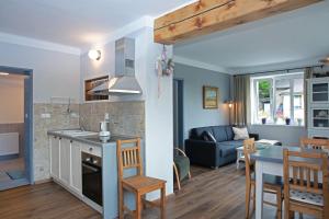 a kitchen and living room with a couch and a table at Apartments Michovka in Koberovy