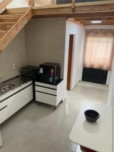 a kitchen with a microwave and a table in it at Loft BR 282 in Lages