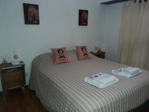 una camera con un letto con due cuscini sopra di FRIDA APARTMENT remis gratis a Ezeiza a Ezeiza