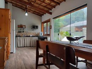 a kitchen with a counter and a large window at Casa Luz do Sol Ubatuba in Ubatuba