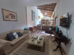 a living room with a couch and a piano at Casa Luz do Sol Ubatuba in Ubatuba