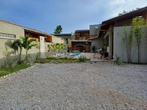 a house with a gravel driveway next to a building at Casa Luz do Sol Ubatuba in Ubatuba