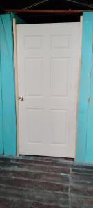 a white garage door in a room with blue walls at Hospedaje y jardin botanico chiltun maya in El Remate