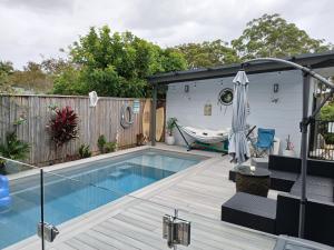 a small backyard with a swimming pool and a house at Our Retreat in Forster