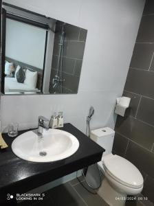 uma casa de banho com um lavatório, um WC e um espelho. em LS HOTEl em Kim Bảng