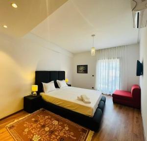 um quarto com uma cama grande e um sofá vermelho em Paradise Prestigia em Fez