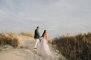 uma noiva e um noivo caminhando na praia em Southern Charm of Holden Beach em Holden Beach