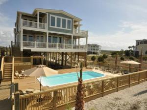 uma casa grande com uma piscina em frente em Southern Charm of Holden Beach em Holden Beach