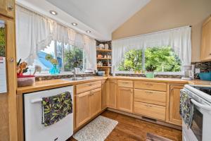 a kitchen with wooden cabinets and white appliances at Cozy Creekside Retreat in Hillier