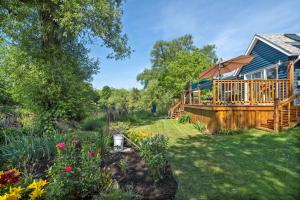 a garden with flowers and a house at Cozy Creekside Retreat in Hillier