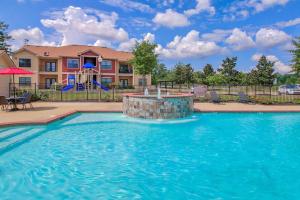 - une piscine avec une fontaine en face d'une maison dans l'établissement Magnolia Serenity: 2BD/1BA w/ Gym, Pool, BBQ Grill, à Tupelo
