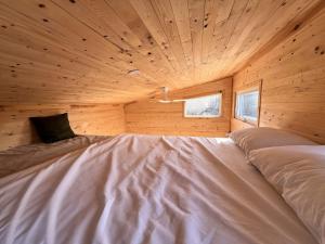 a room with a bed in a wooden cabin at Cozy Creekside Retreat in Hillier