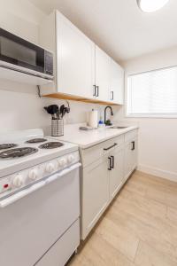 a kitchen with white cabinets and a stove at Quaint 1 BD 1 BTH Guest Home Minutes from Gonzaga in Spokane