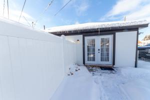 a small white house with a door in the snow at Quaint 1 BD 1 BTH Guest Home Minutes from Gonzaga in Spokane