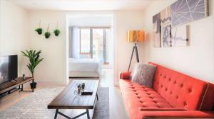 uma sala de estar com um sofá vermelho e uma mesa em 75-4C New Duplex 3BR W D Elevator Walk to C park em Nova York