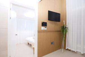 a room with a tv on a wall with a bed at The Loft Homely in Seoul