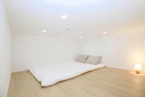 a white room with a bed in the ceiling at The Loft Homely in Seoul
