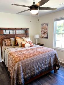 a bedroom with a large bed with a ceiling fan at Fun House at SML Adventure filled Lake Retreat in Huddleston