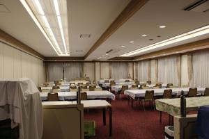 Habitación grande con mesas y sillas. en Fuji Yamanakako Hotel en Yamanakako