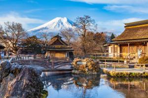 a japanese temple with a snow mountain in the background at Fuji Yamanakako Hotel in Yamanakako