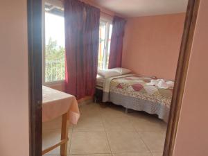 Habitación pequeña con cama y ventana en casamares - casanon, en San José Pinula