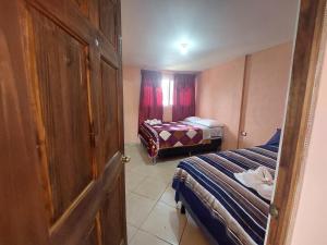 a small room with two beds and a door at casamares - casanon in San José Pinula