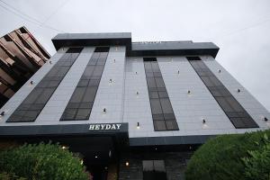 een groot gebouw met een vrolijk dagbord erop bij Hey Day Hotel in Busan