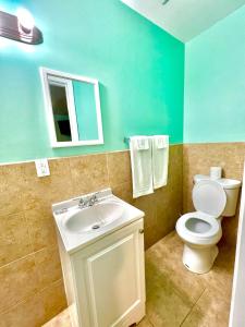 ein Badezimmer mit einem WC, einem Waschbecken und einem Spiegel in der Unterkunft Your Motel in Ypsilanti