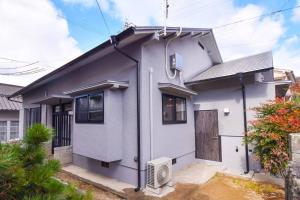 uma casa branca com uma porta em GuestHouseYULLAT em Horiechō