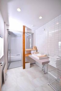 uma casa de banho branca com 2 lavatórios e um chuveiro em GuestHouseYULLAT em Horiechō