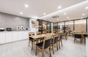 una sala da pranzo con tavoli e sedie in legno di H-Evian Hotel a Gwangju