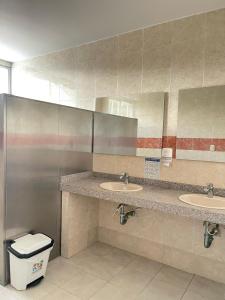 a public bathroom with two sinks and a mirror at Hotel Fundacooedumag Rodadero in Santa Marta