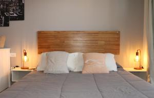 1 cama con 2 almohadas y cabecero de madera en Chula Vista - Depto con vista al mar en Punta Mogotes en Mar del Plata