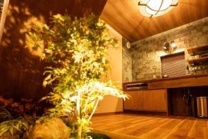 a living room with a tree in the middle of a room at 旅宿うさぎとかめ Guest House USAGI to KAME 近江八幡中心地 ヴォーリズ建築好きにお勧め in Hachiman