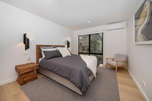 um quarto com uma cama e uma grande janela em Blairgowrie Beach Abode em Blairgowrie