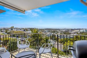a balcony with chairs and a view of the ocean at 2-Bed near Beach with BBQ & Stunning Ocean Views in Alexandra Headland