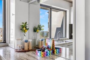 a kitchen with a sink and a window at 2-Bed near Beach with BBQ & Stunning Ocean Views in Alexandra Headland