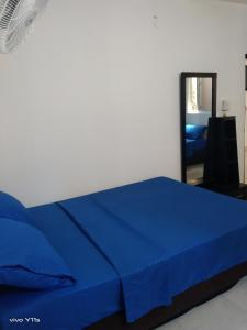 Una cama azul en una habitación con espejo en Apartamento Erika 301 en el centro de Santa Marta, en Santa Marta