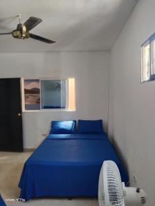 1 dormitorio con 1 cama azul y ventilador en Apartamento Erika 301 en el centro de Santa Marta, en Santa Marta