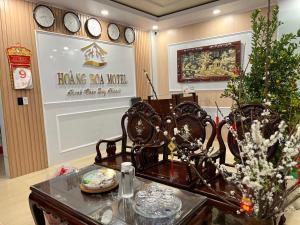 ein Esszimmer mit einem Tisch und Uhren an der Wand in der Unterkunft Nhà Nghỉ Hoàng Hoa in Buon Ma Thuot