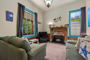 a living room with a couch and a fireplace at India House & Ica Whare in Whareama, Nr Riversdale Beach in Whareama