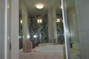 een badkamer met een bad, een wastafel en een spiegel bij Acolhedor Apartamento Em Alfama in Lissabon +11 foto's