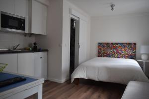 een slaapkamer met een bed met een schilderij aan de muur bij Acolhedor Apartamento Em Alfama in Lissabon