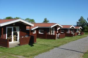 a row of wooden cottages in a row at Sandkaas Family Camping & Cottages in Allinge