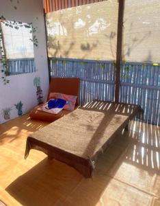 - un lit en bois dans une chambre avec fenêtre dans l'établissement Kubo house by the water in ELYU, Ba-ey Ad Shanom, à San Fernando